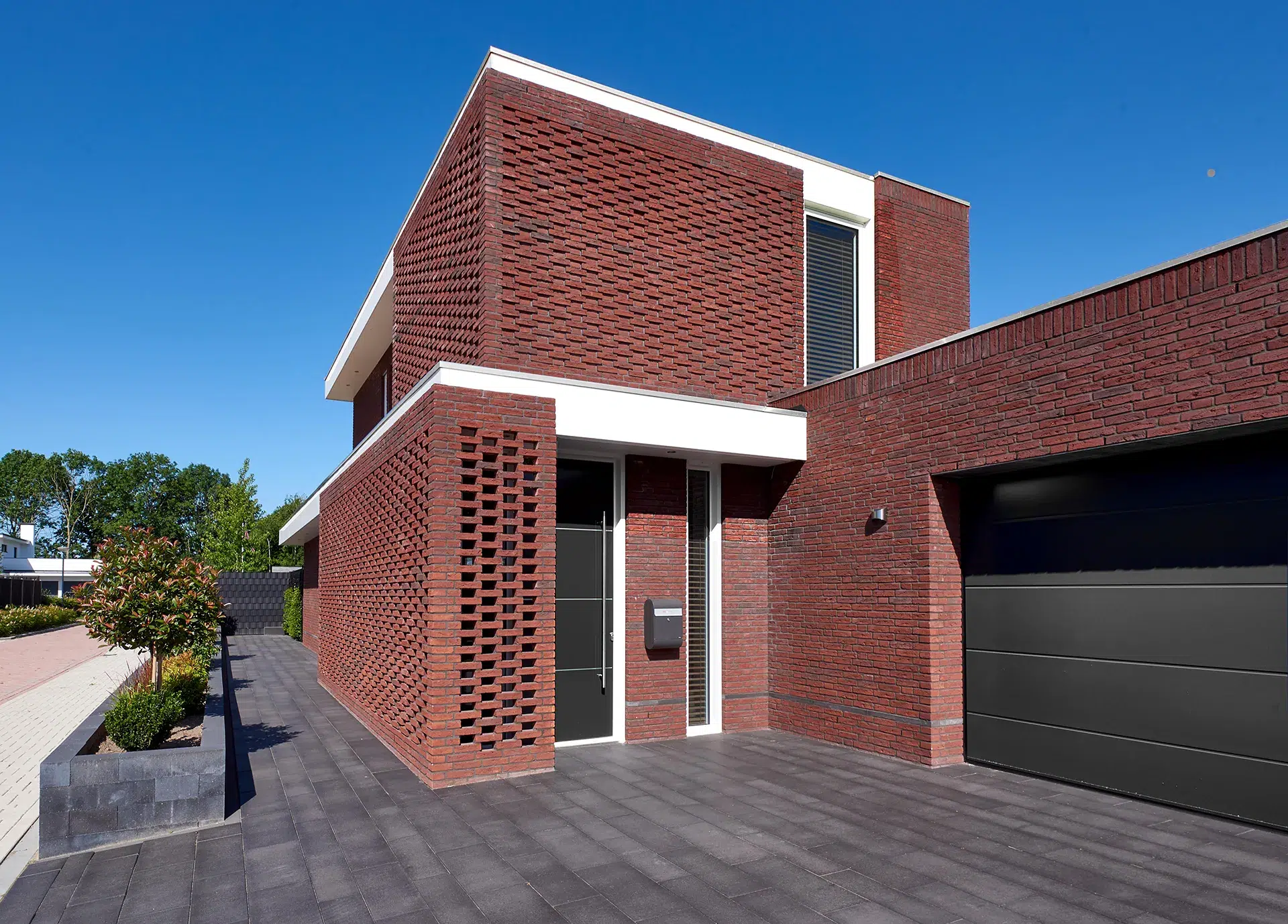 Entree met braziliaans metselwerk verband, witte dakranden en metselwerk met terugliggende koppen.