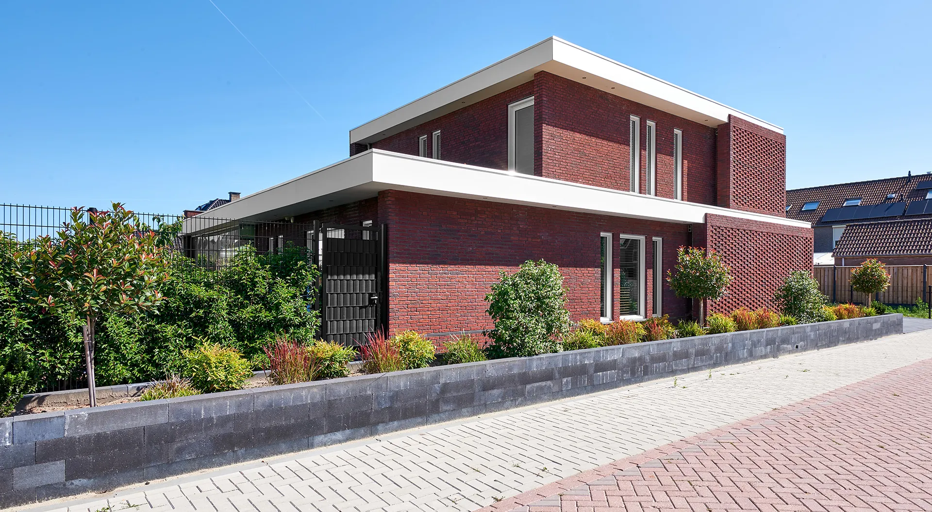 Gemetselde woning met witte dakranden en kozijnen in Waspik.