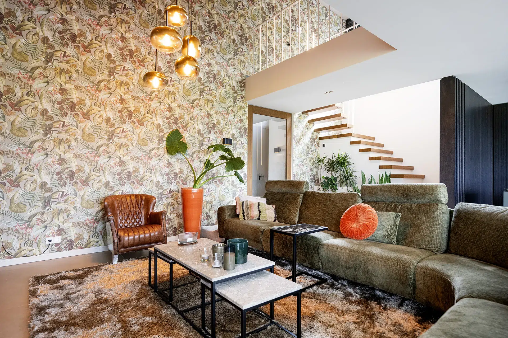 Ruimtelijke woonkamer met vide en grote hanglamp.