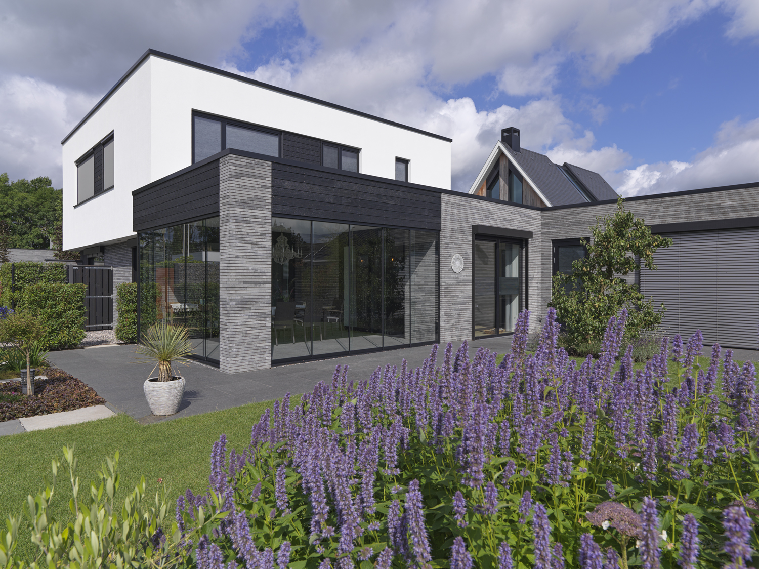 Moderne woning in Waspik met lange gevelstenen van GeoStylistix en wit gestucte verdieping.
