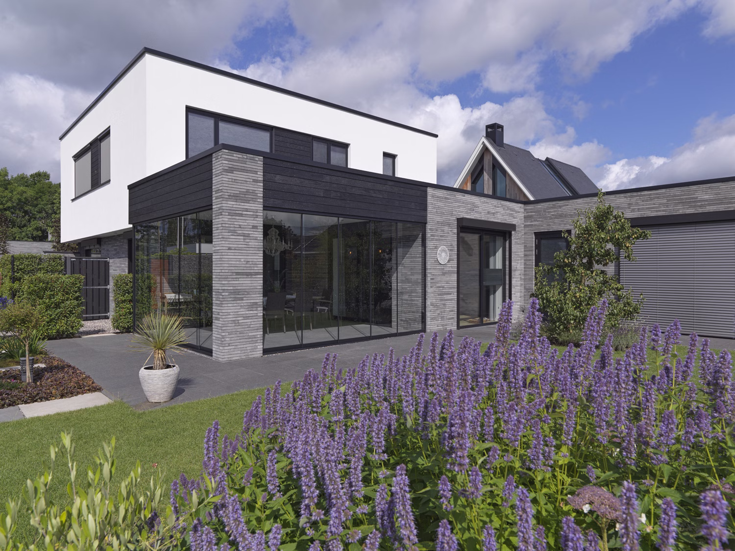 Moderne woning in Waspik met lange gevelstenen van GeoStylistix en wit gestucte verdieping.