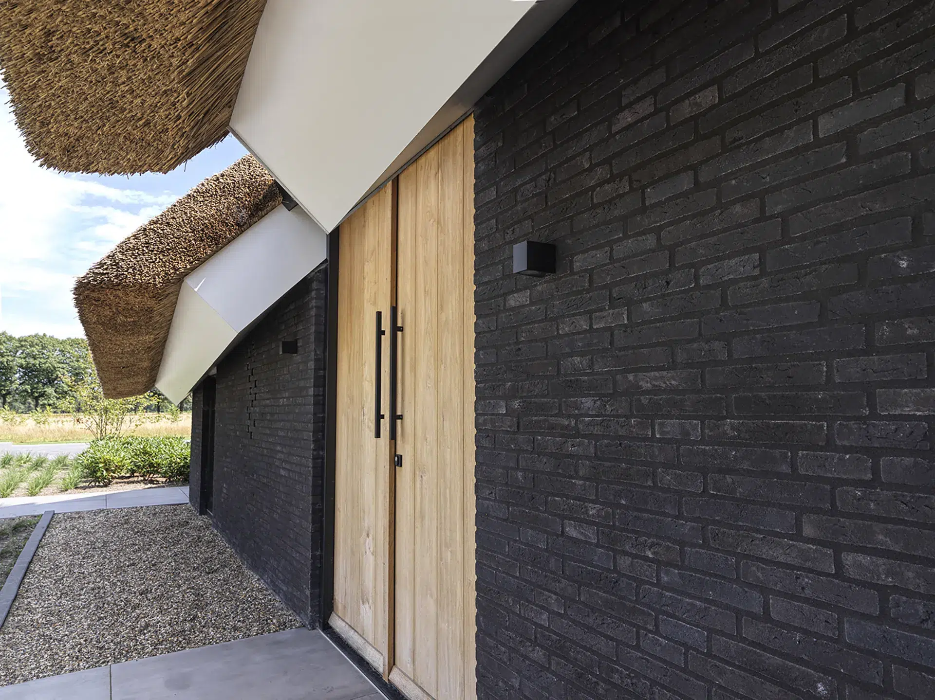 Detail van houten voordeur en overstek van rietgedekt dak.