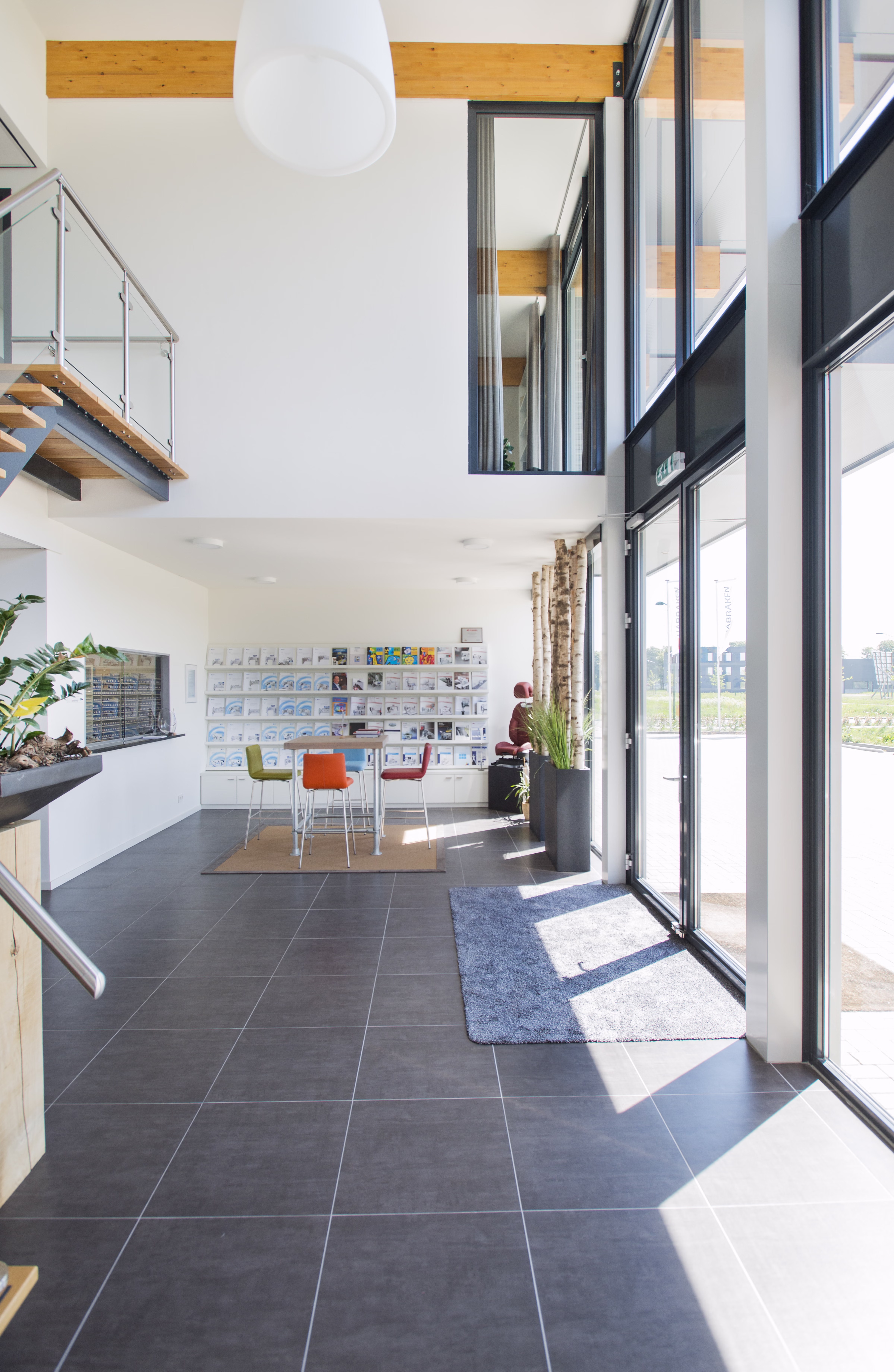 Bedrijfsgebouw met grote glaspartijen, bakstenen gevel en houten luifel voor een comfortabel binnenklimaat.